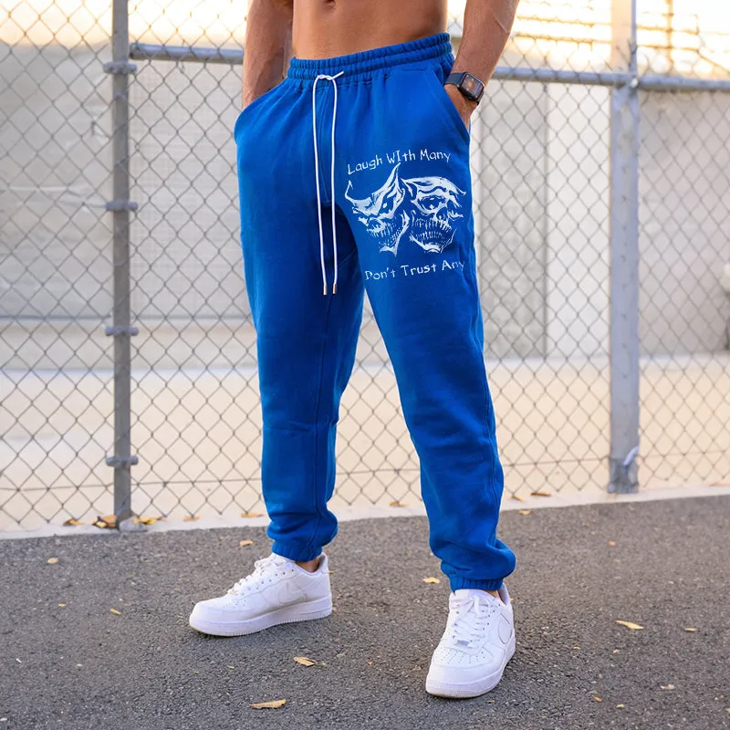 LAUGH WITH MANY, DON’T TRUST ANY SKULLS GRAPHIC PRINT JOGGERS